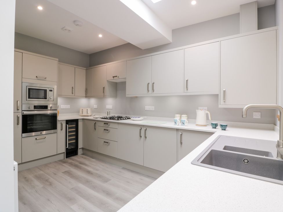 A kitchen with cabinets and appliances at Beach House in Stranraer