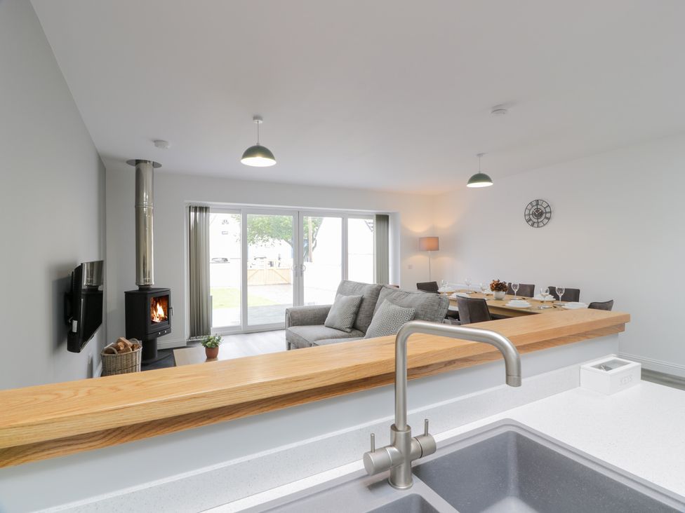 A living room with a stove and dining area at Beach House in Stranraer