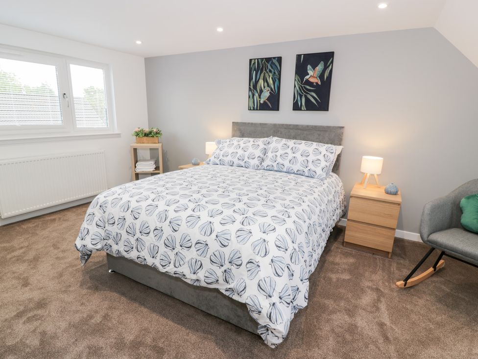 A bedroom with a bed and bedside table at Beach House in Stranraer