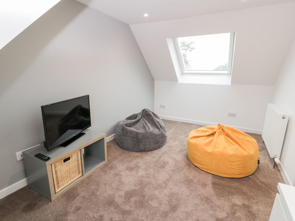A loft room with a television and two bean bag chairs at Beach House in Stranraer