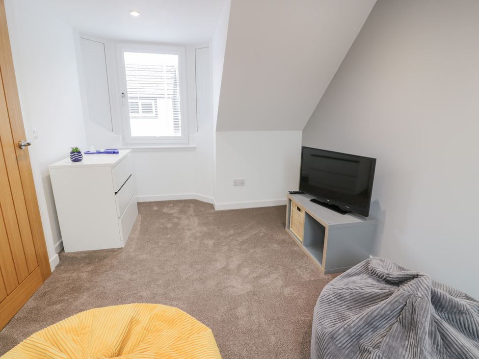 A bedroom with a television and a window at Beach House in Stranraer