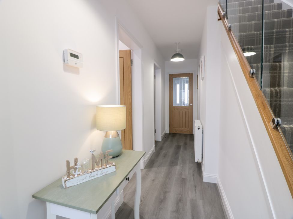 A hallway with a console table and lamp at Beach House in Stranraer