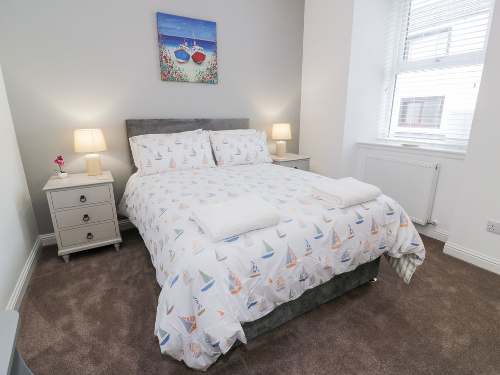 A bedroom with a bed and bedside table at Beach House Stranraer