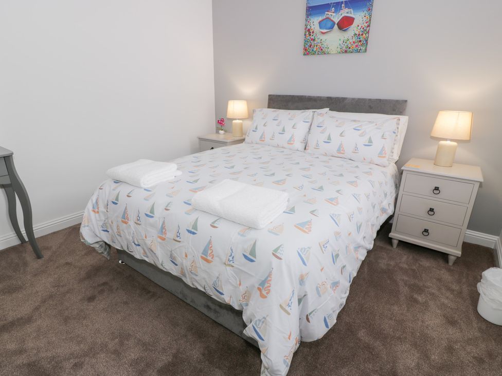 A bedroom with a bed and bedside tables at Beach House in Stranraer