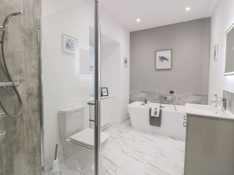 A bathroom with a shower and a bathtub at Beach House in Stranraer