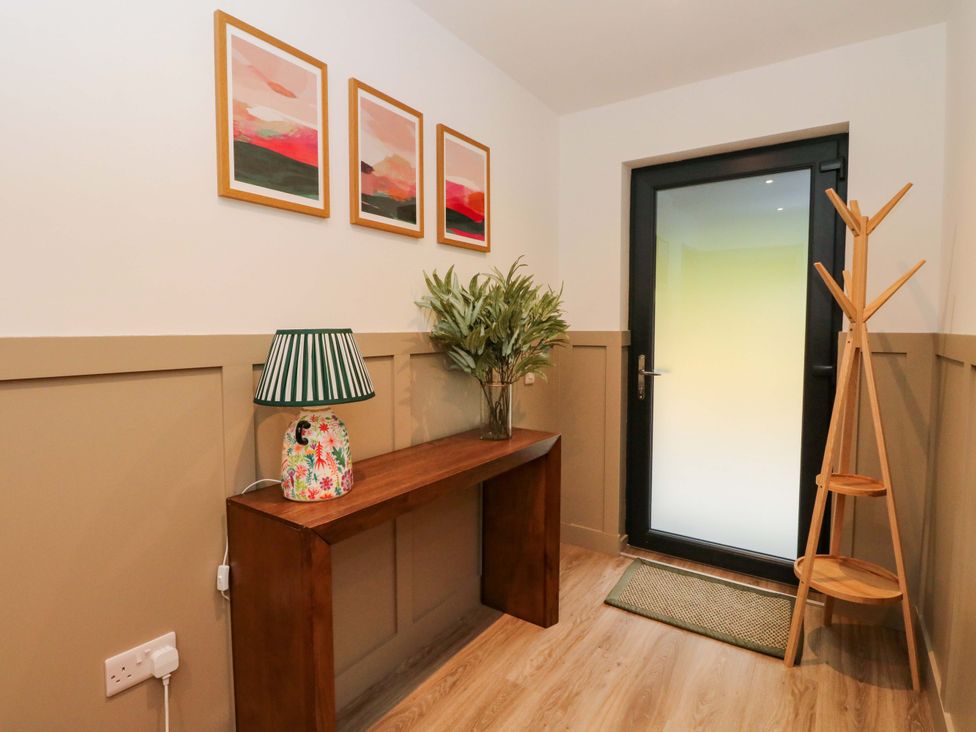 A hallway with a console table and lamp at Nevis Bridge House in Fort William