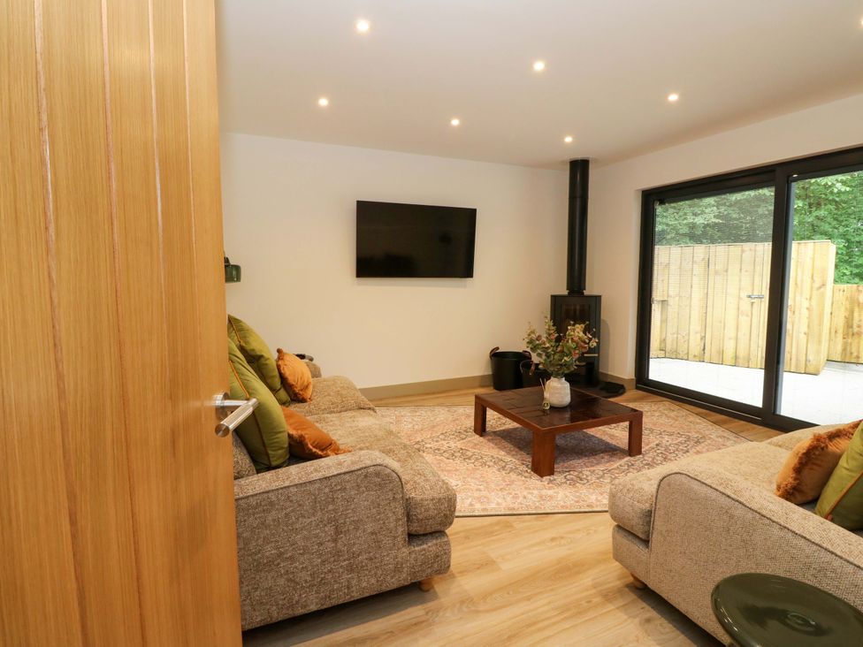 A living room with a television and coffee table at Nevis Bridge House in Fort William