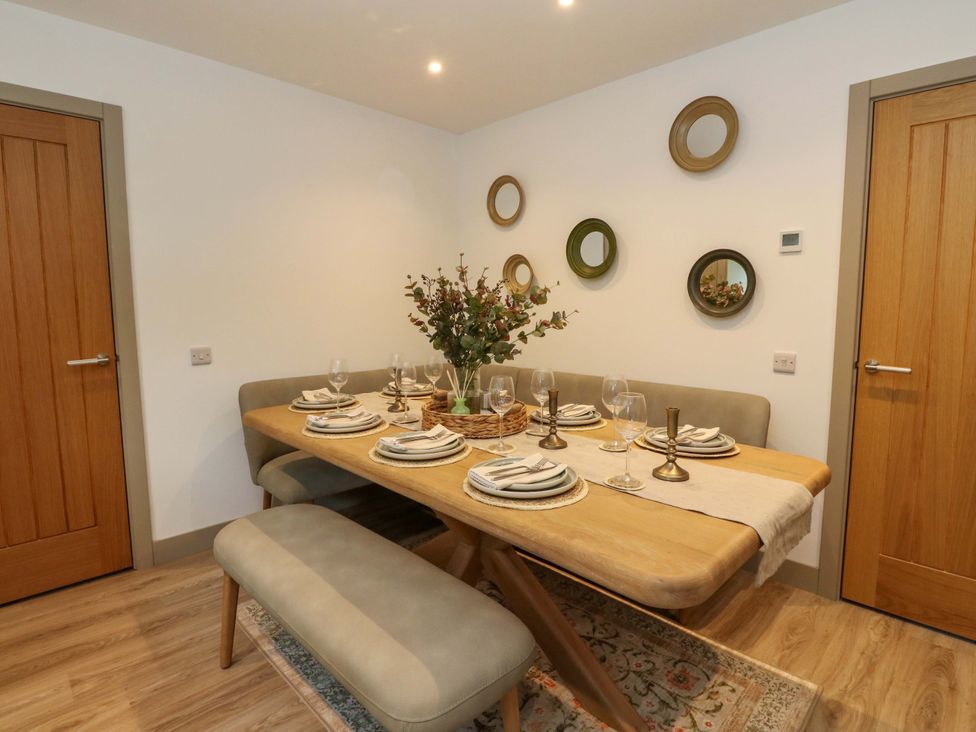 A dining room with a table set for a meal at Nevis Bridge House in Fort William