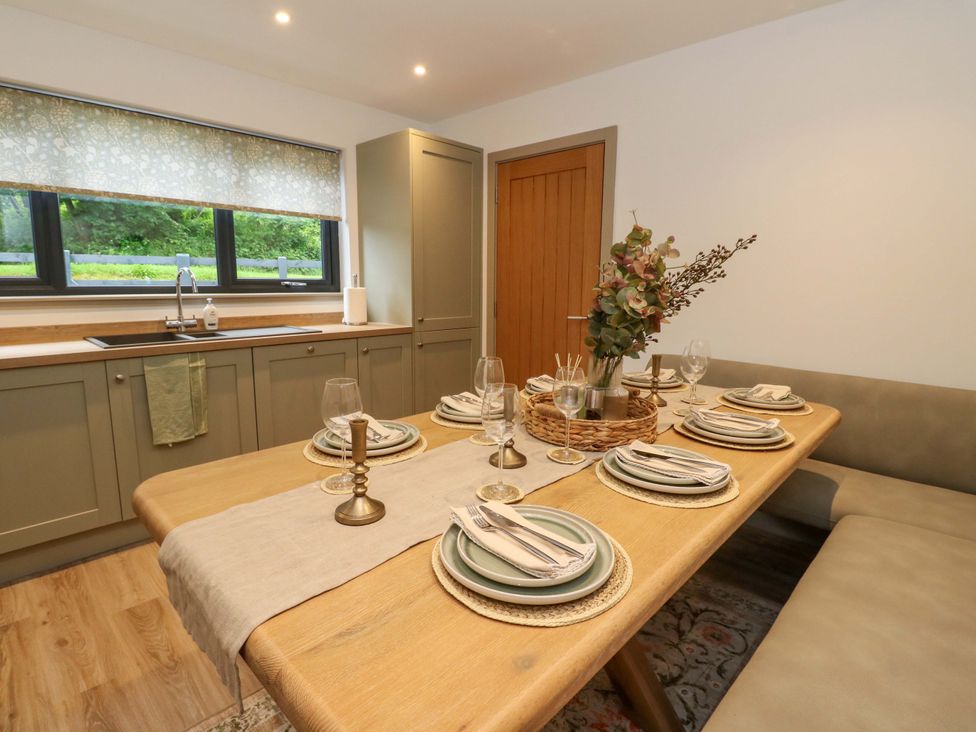 A dining room with a table set with plates and glasses at Nevis Bridge House Fort William