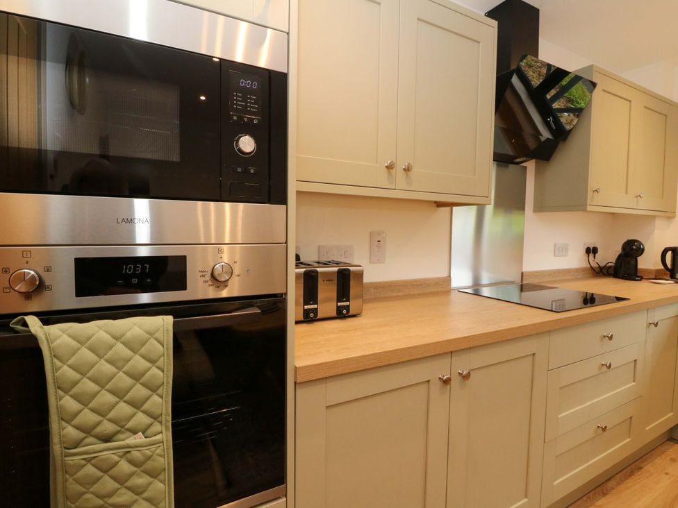 A kitchen with microwave, oven, cooktop, and counter space at Nevis Bridge House in Fort William