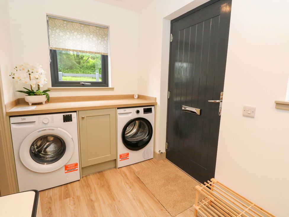 A laundry room with washing machine and dryer at Nevis Bridge House in Fort William