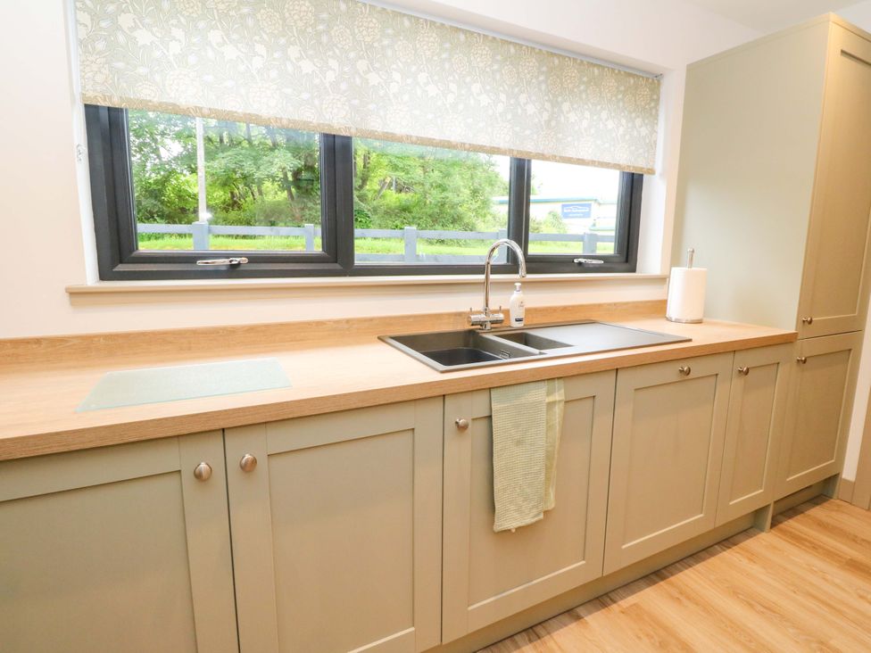A kitchen with a sink and cabinets at Nevis Bridge House in Fort William