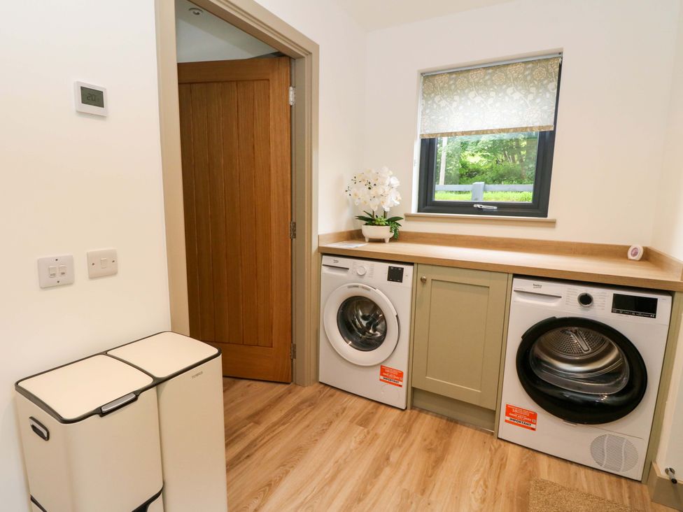 A laundry room with a washing machine and tumble dryer at Nevis Bridge House in Fort William