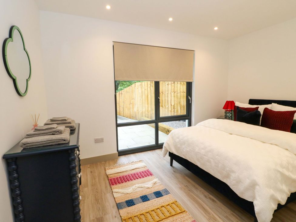 A bedroom with a bed and dresser at Nevis Bridge House in Fort William