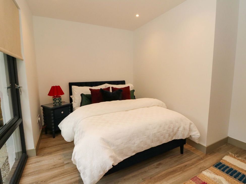 A bedroom with a bed and nightstand at Nevis Bridge House in Fort William