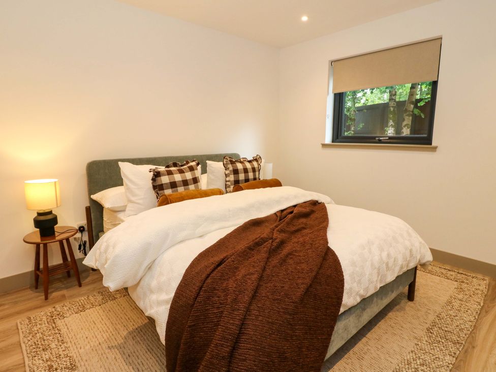 A bedroom with a bed and lamp at Nevis Bridge House in Fort William