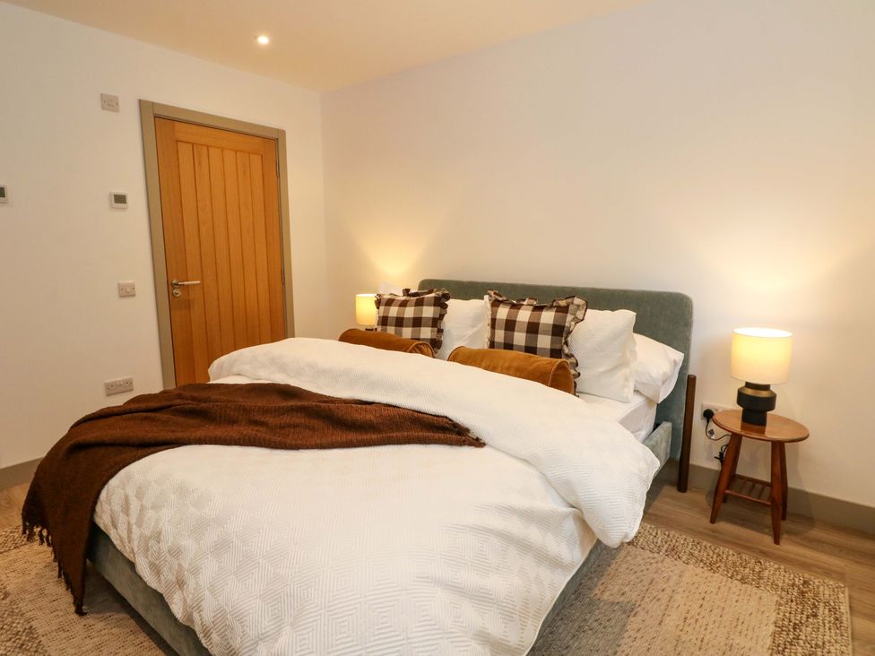 A bedroom with a bed and lamp at Nevis Bridge House in Fort William