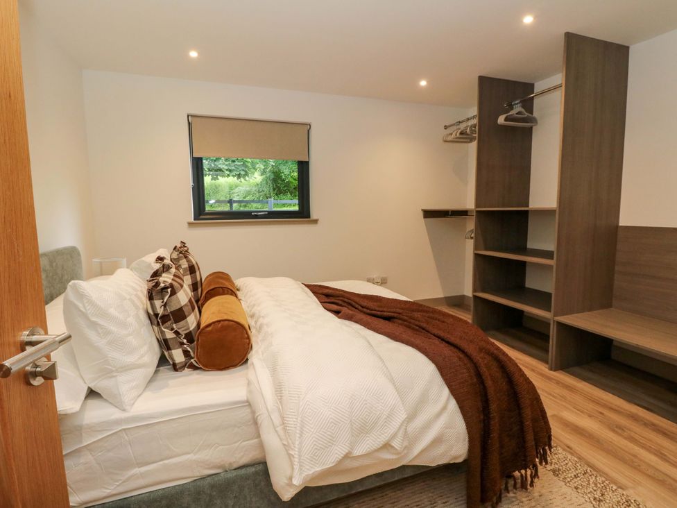 A bedroom with a bed and wardrobe at Nevis Bridge House Fort William