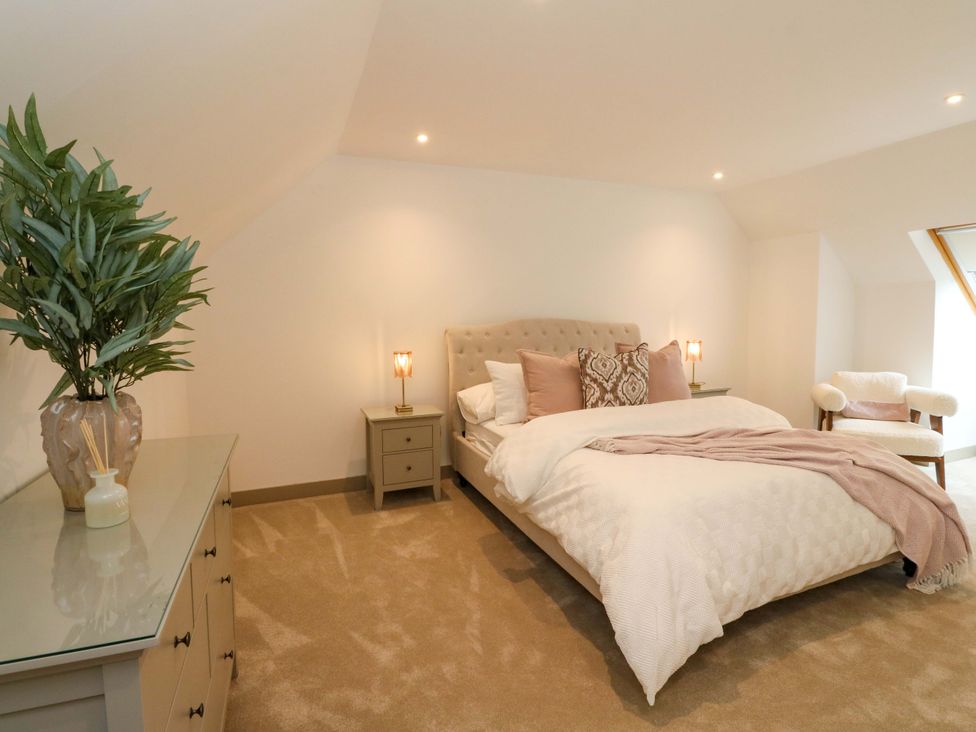 A bedroom with a bed, nightstand, and plant at Nevis Bridge House in Fort William