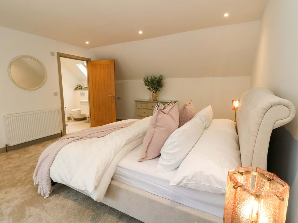 A bedroom with a bed and a door leading to a bathroom at Nevis Bridge House in Fort William