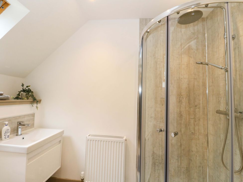 A bathroom with a shower and sink at Nevis Bridge House Fort William
