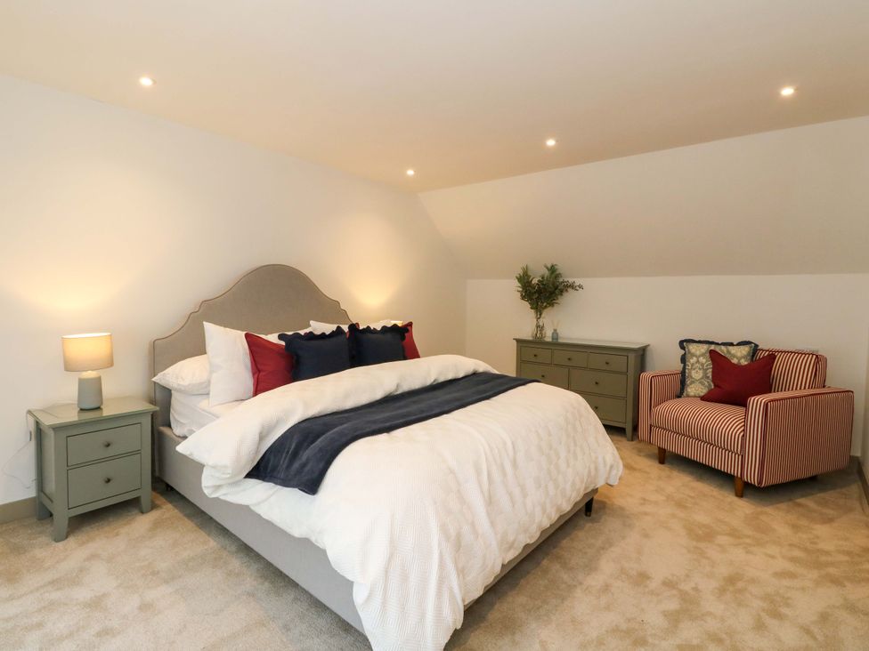 A bedroom with a bed and a chair at Nevis Bridge House Fort William
