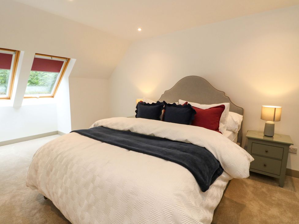A bedroom with a bed and two windows at Nevis Bridge House Fort William