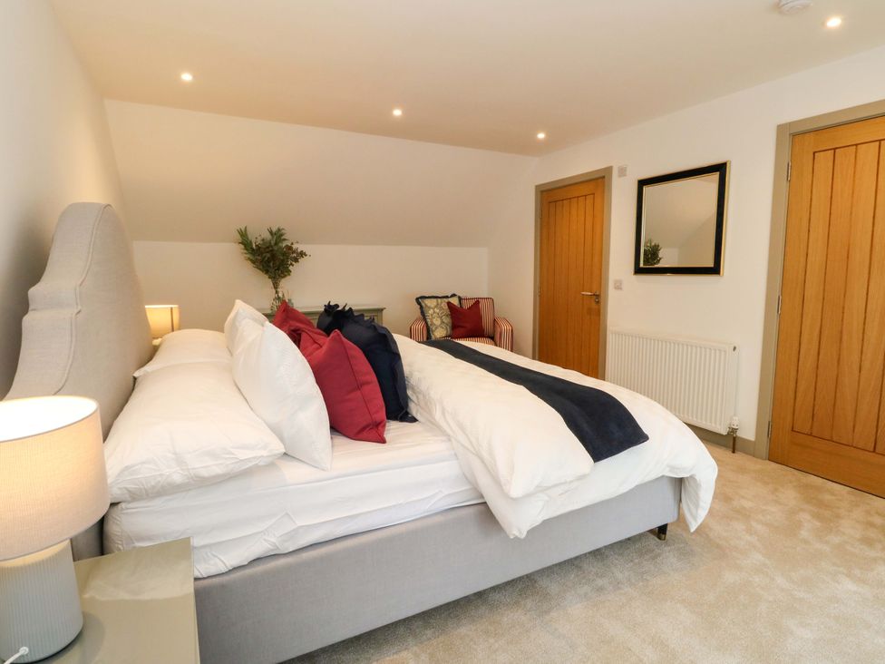 A bedroom with a bed and a chair at Nevis Bridge House in Fort William