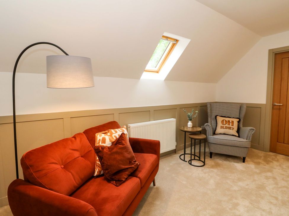 A living room with a sofa and chair at Nevis Bridge House in Fort William