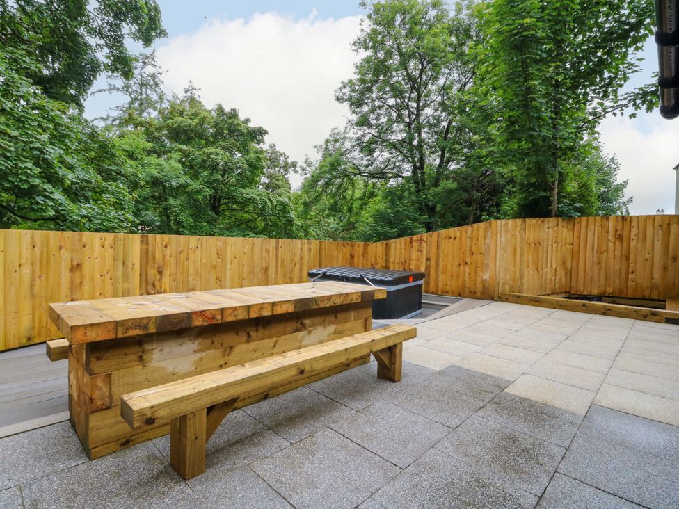 An outdoor area with a wooden bench and hot tub at Nevis Bridge House Fort William