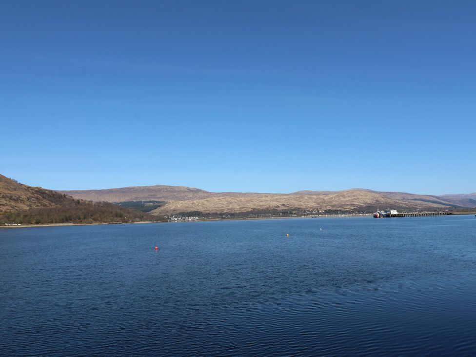 A view of water with mountains and a pier at Nevis Bridge House Fort William