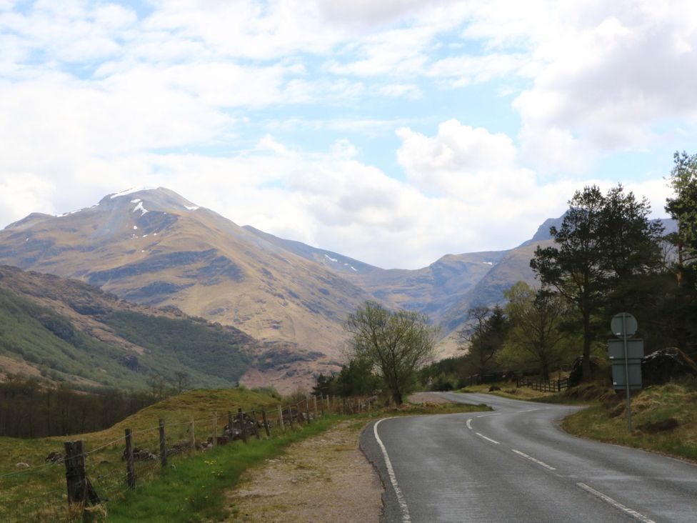 A road surrounded by mountains and trees at Nevis Bridge House in Fort William