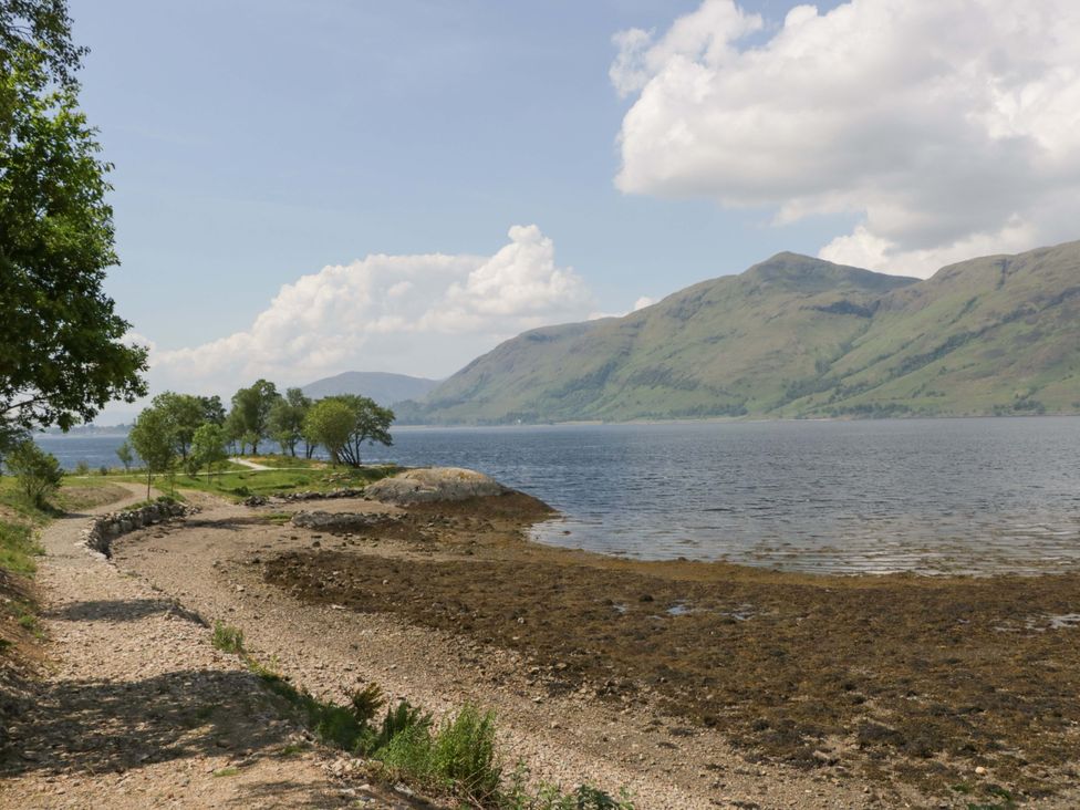 A lake with mountains in the background at Nevis Bridge House Fort William