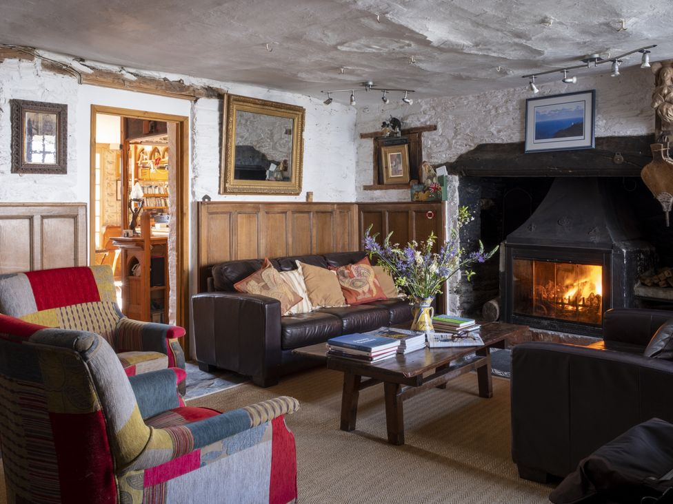 A living room with a fireplace and seating at Manor Farmhouse in Dittisham