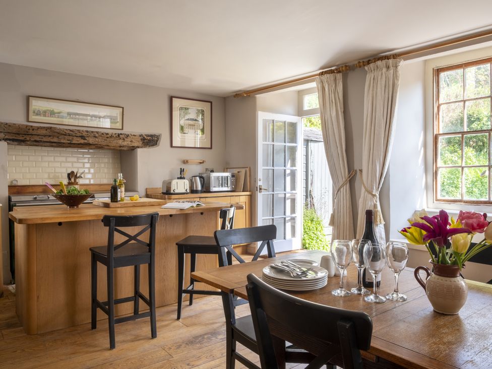 A kitchen with an island and dining table at Manor Farmhouse Dittisham