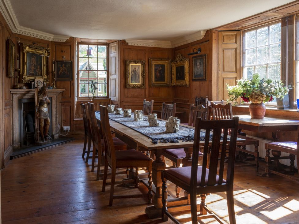 A dining room with a large table and chairs at Manor Farmhouse in Dittisham