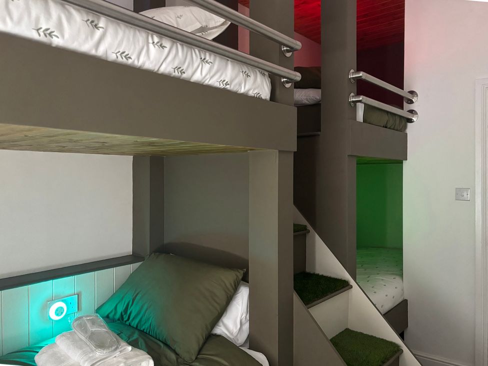 A bedroom with a bunk bed and stairs at The Miners Hall Retreat, Stanley, County Durham