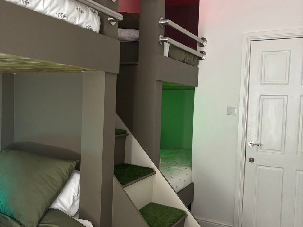 A bedroom with bunk beds and pillows at The Miners Hall Retreat in Stanley, County Durham