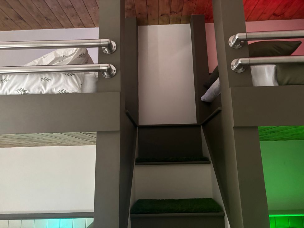 A bedroom with bunk beds and stairs at The Miners Hall Retreat in Stanley, County Durham