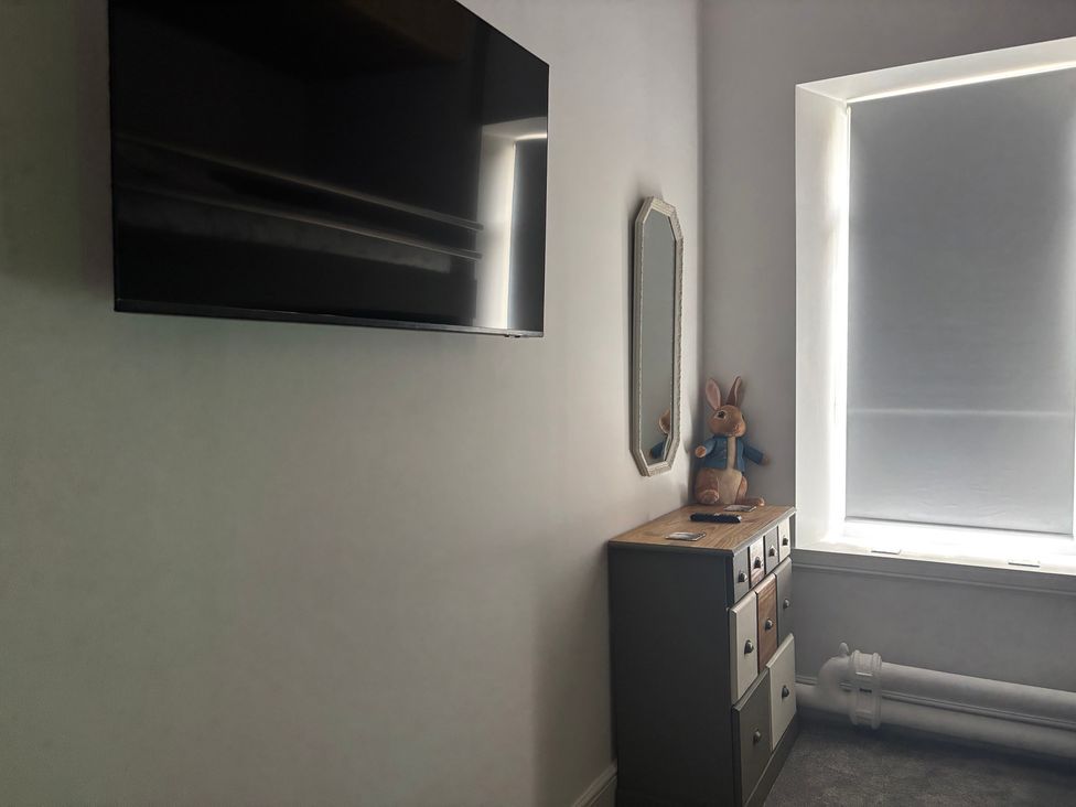 A bedroom with a television and a soft toy at The Miners Hall Retreat in Stanley, County Durham