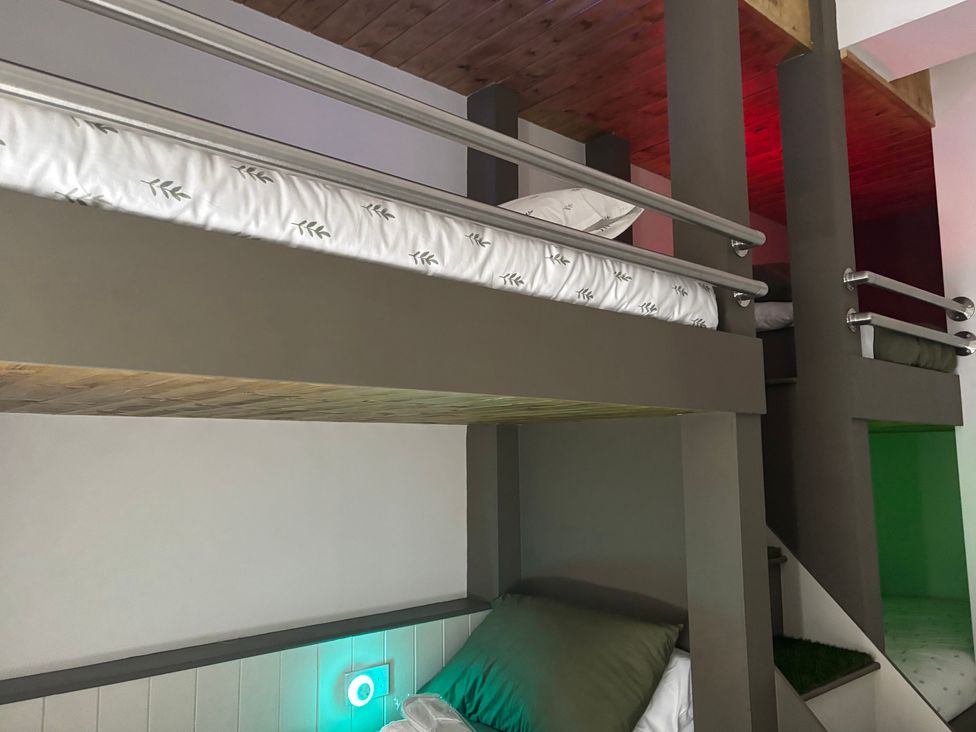 A bunk bed with a mattress and bedside light at The Miners Hall Retreat in Stanley, County Durham