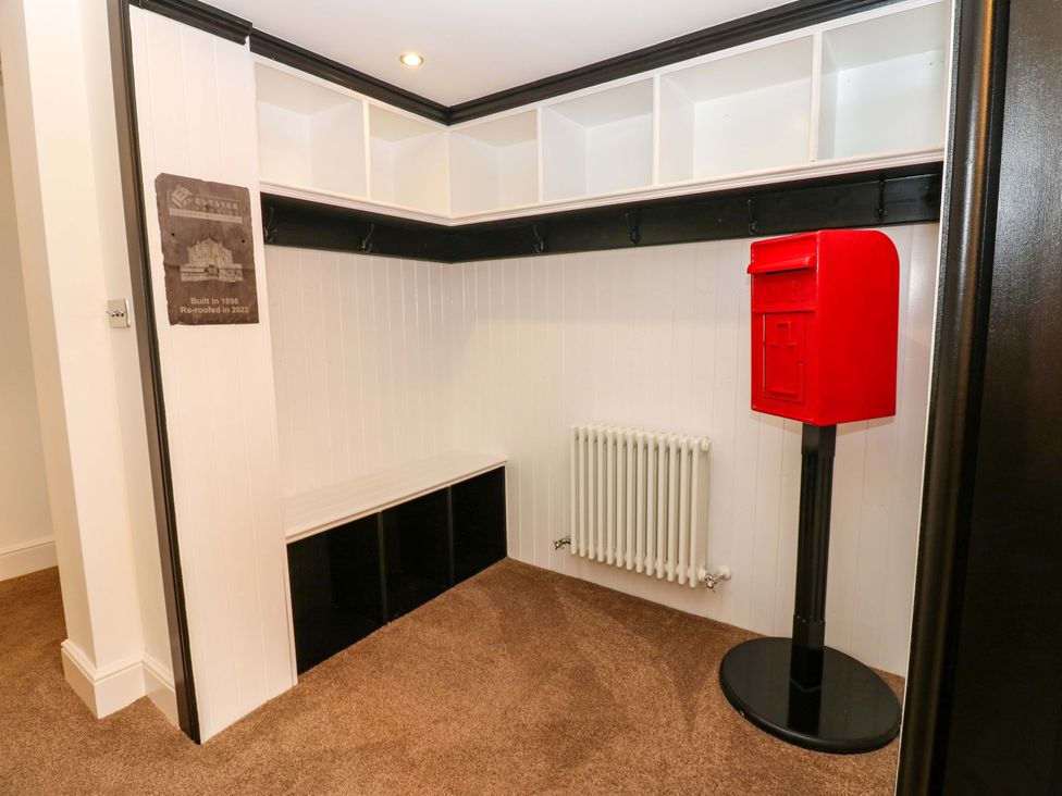 An entryway with a coat hooks and a red post box at The Miners Hall Retreat Stanley, County Durham
