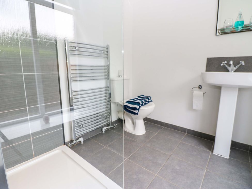 A bathroom with a shower and sink at The Miners Hall Retreat in Stanley, County Durham
