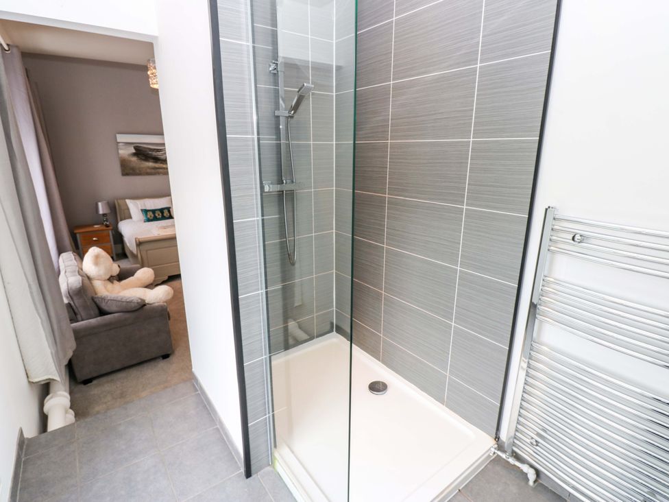 A shower enclosure with a towel rail at The Miners Hall Retreat in Stanley, County Durham