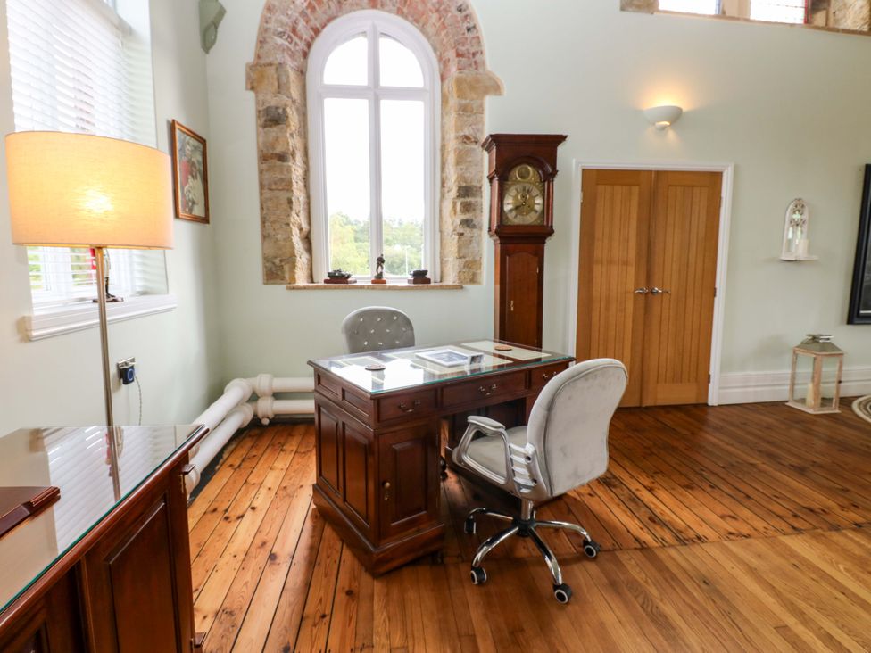 An office with a wooden desk and chair at The Miners Hall Retreat in Stanley, County Durham