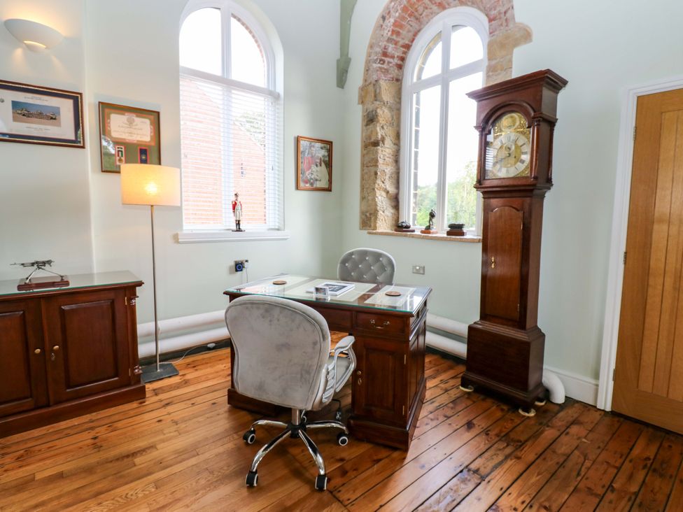 An office with a desk and a clock at The Miners Hall Retreat in Stanley, County Durham