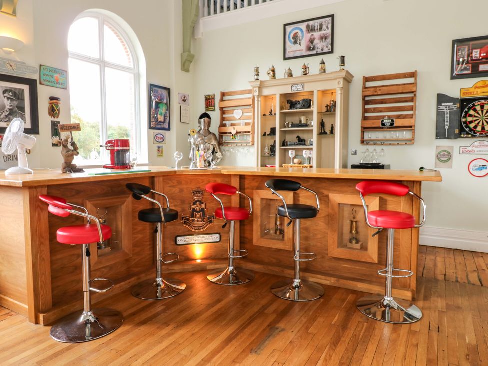 A bar area with stools and decorative items at The Miners Hall Retreat in Stanley, County Durham