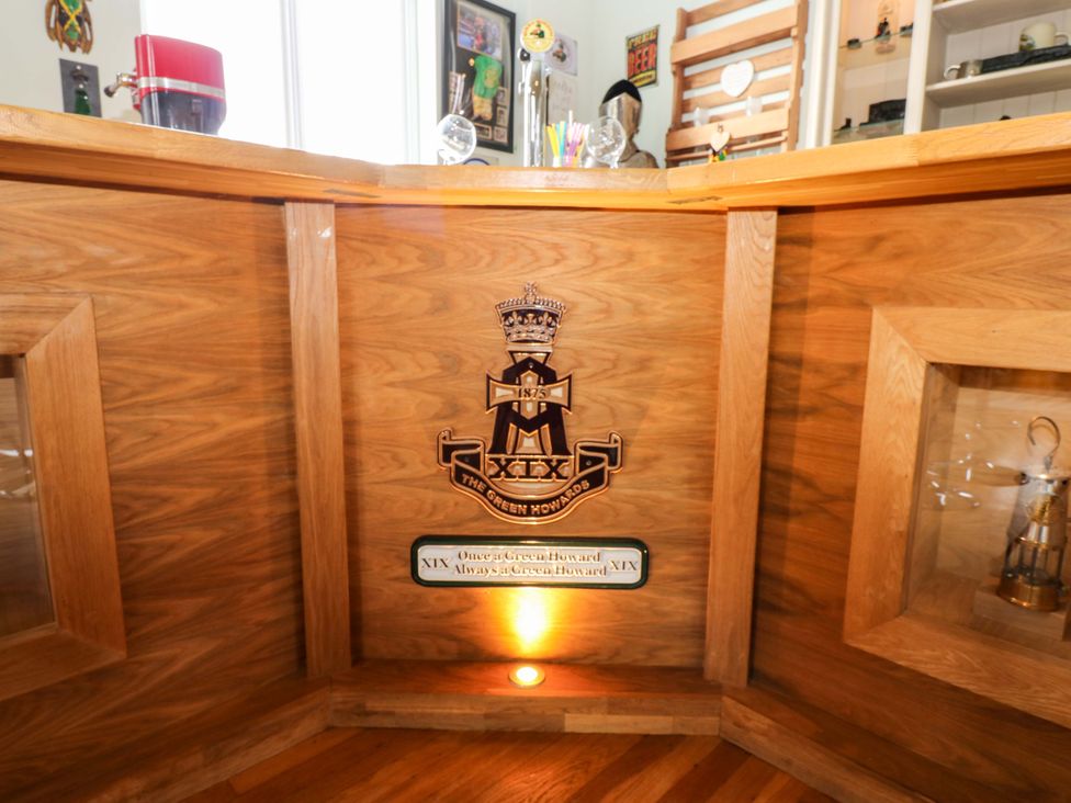 A bar with wooden surfaces and an emblem at The Miners Hall Retreat, Stanley, County Durham