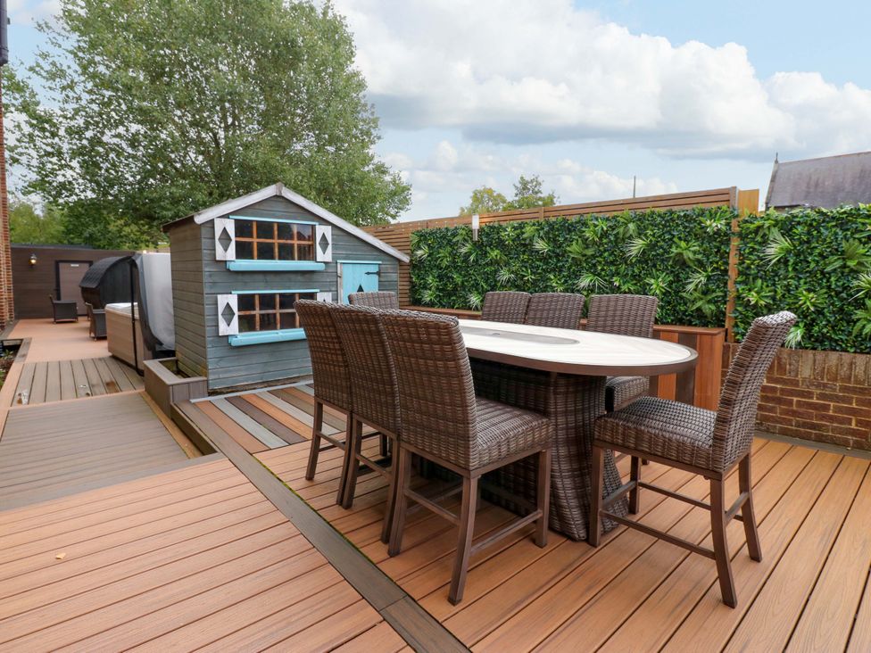 A garden with an outdoor table and chairs and a playhouse at The Miners Hall Retreat in Stanley, County Durham