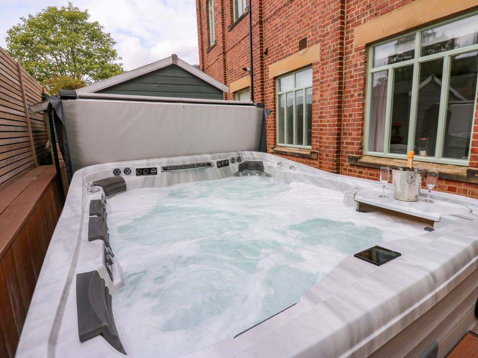 A hot tub with wine glasses at The Miners Hall Retreat in Stanley, County Durham